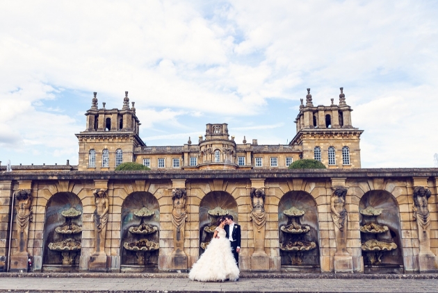 Bridal couple pose in front of Blenheim Palace