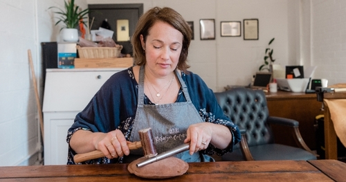 craftswoman makes jewellery in her workshop