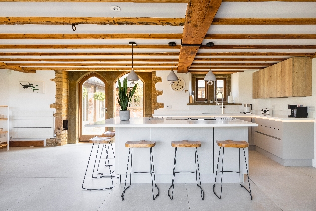 barn-style kitchen with white walls exposed beams modern fittings