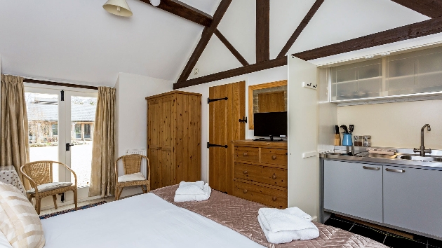 double bed in a rustic room with kitchenette