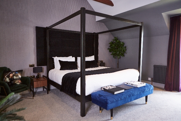 four poster bedroom with armchair and ottoman