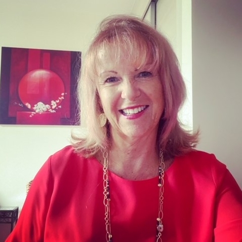 celebrant Susie Mitchell in a red top and gold necklace