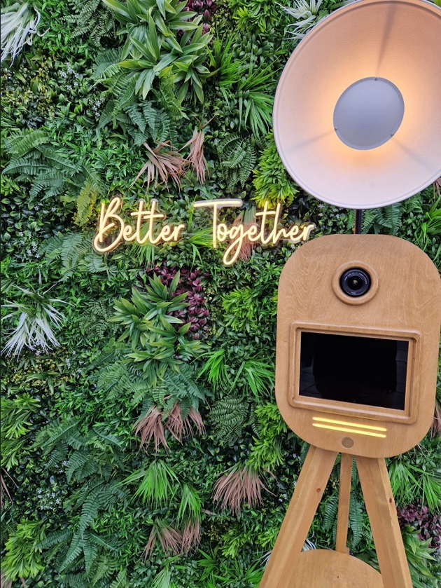wooden photo booth style camera with green backdrop