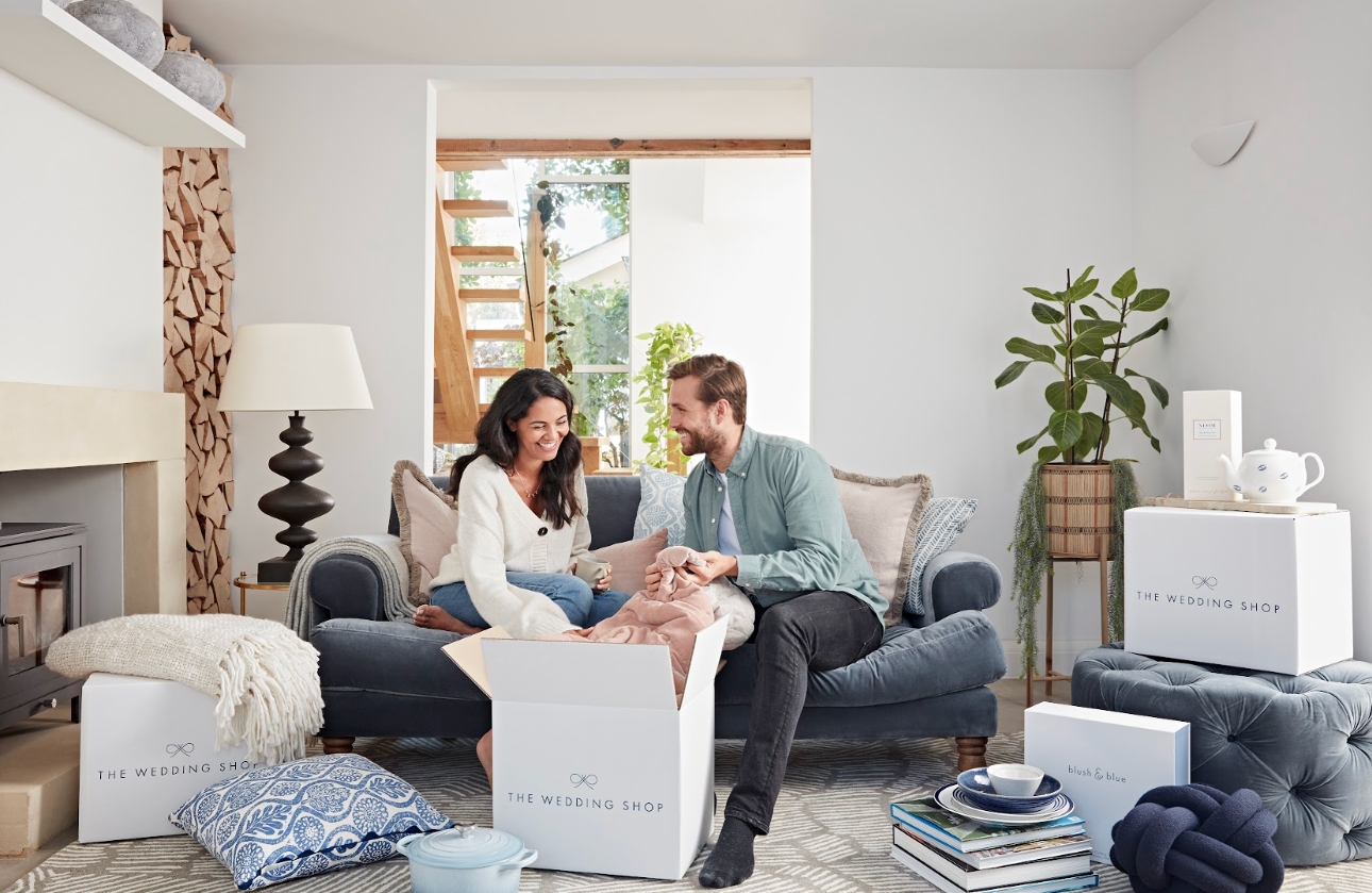 couple opening gifts together on sofa