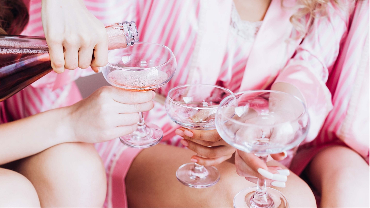 group of women in pink robes with champagne flutes