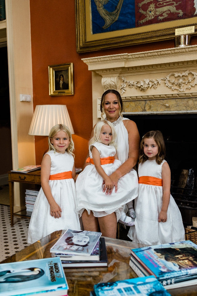bride and flowergirls in white dresses with orange sash