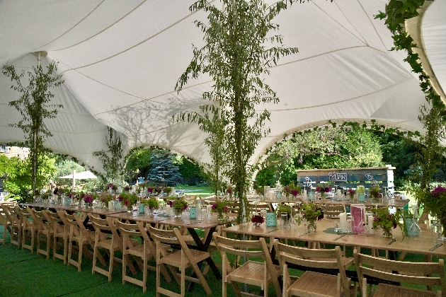 wooden dining tables in a wedding reception marquee
