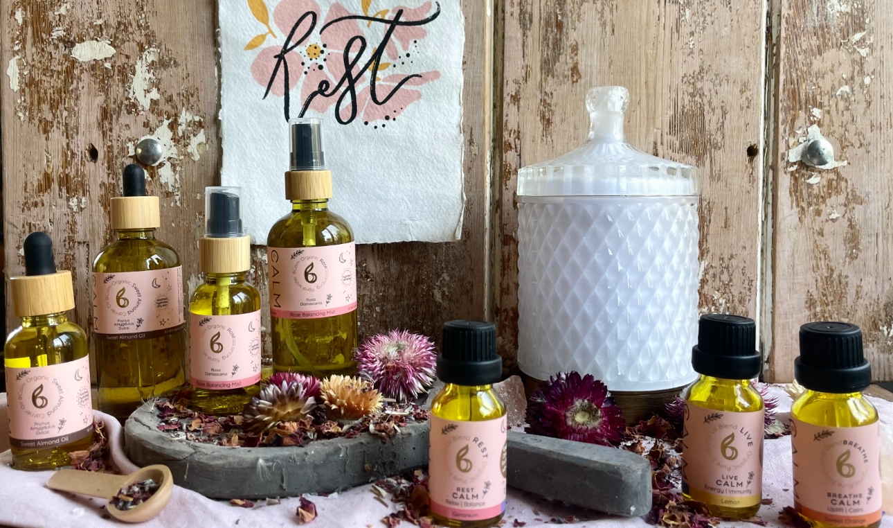 collection of branded glass jars with wooden backdrop and scattered dried flowers