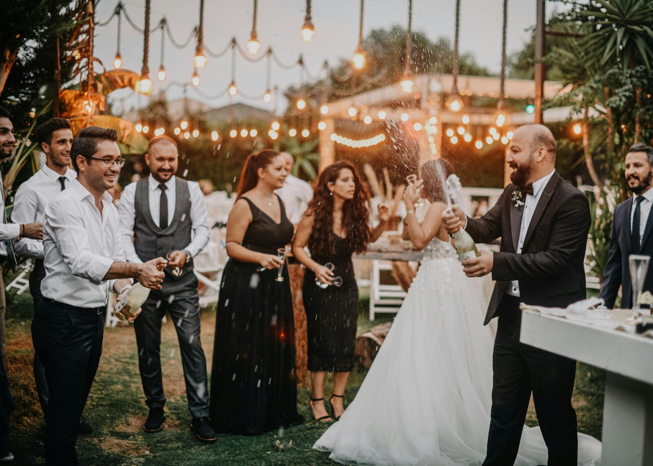 groom and bride having drinks outside by bar