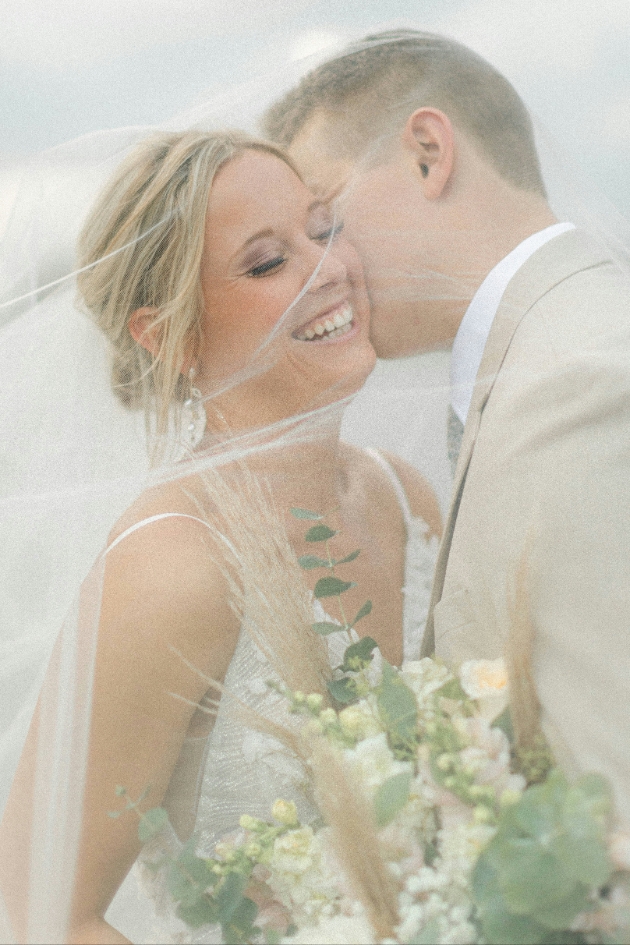 bride and groom under a veil