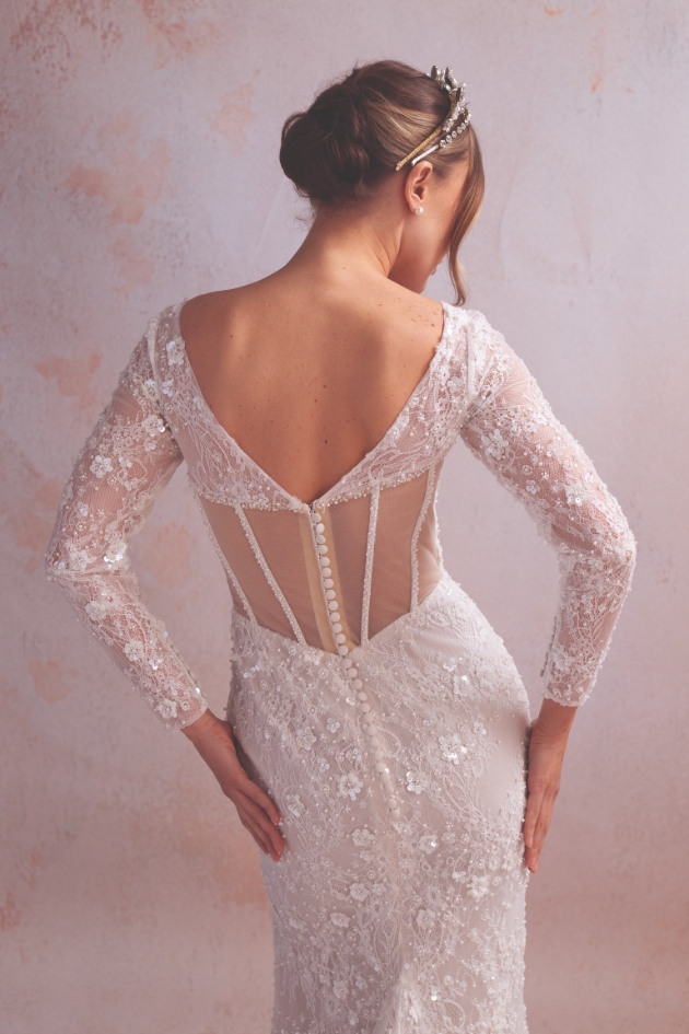 woman posing in low back wedding dress with intricate details