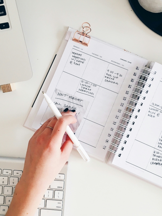 woman writing things down in a planner
