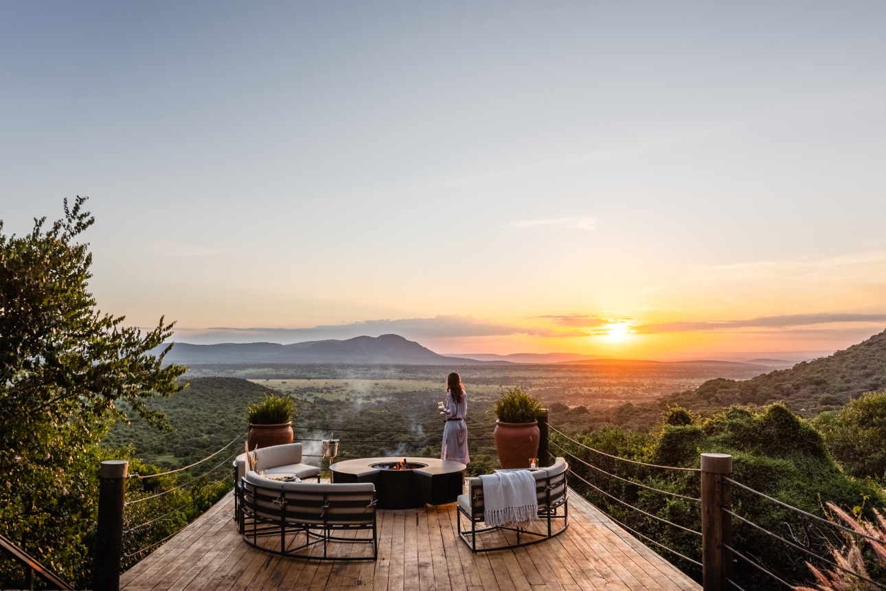 woman stood on balcony looking at the sunset