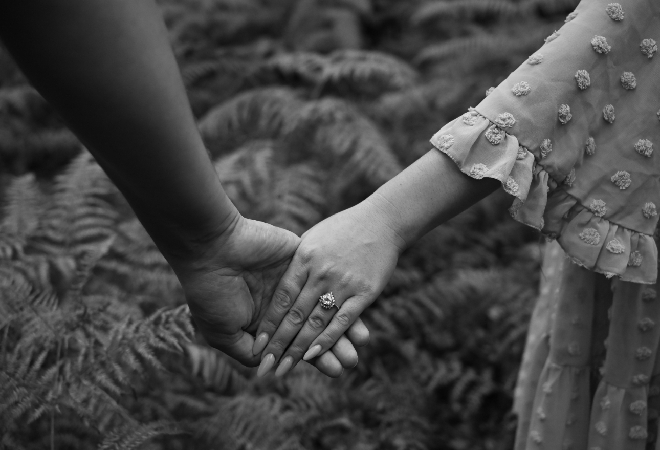 black and white image of a couple holding hands